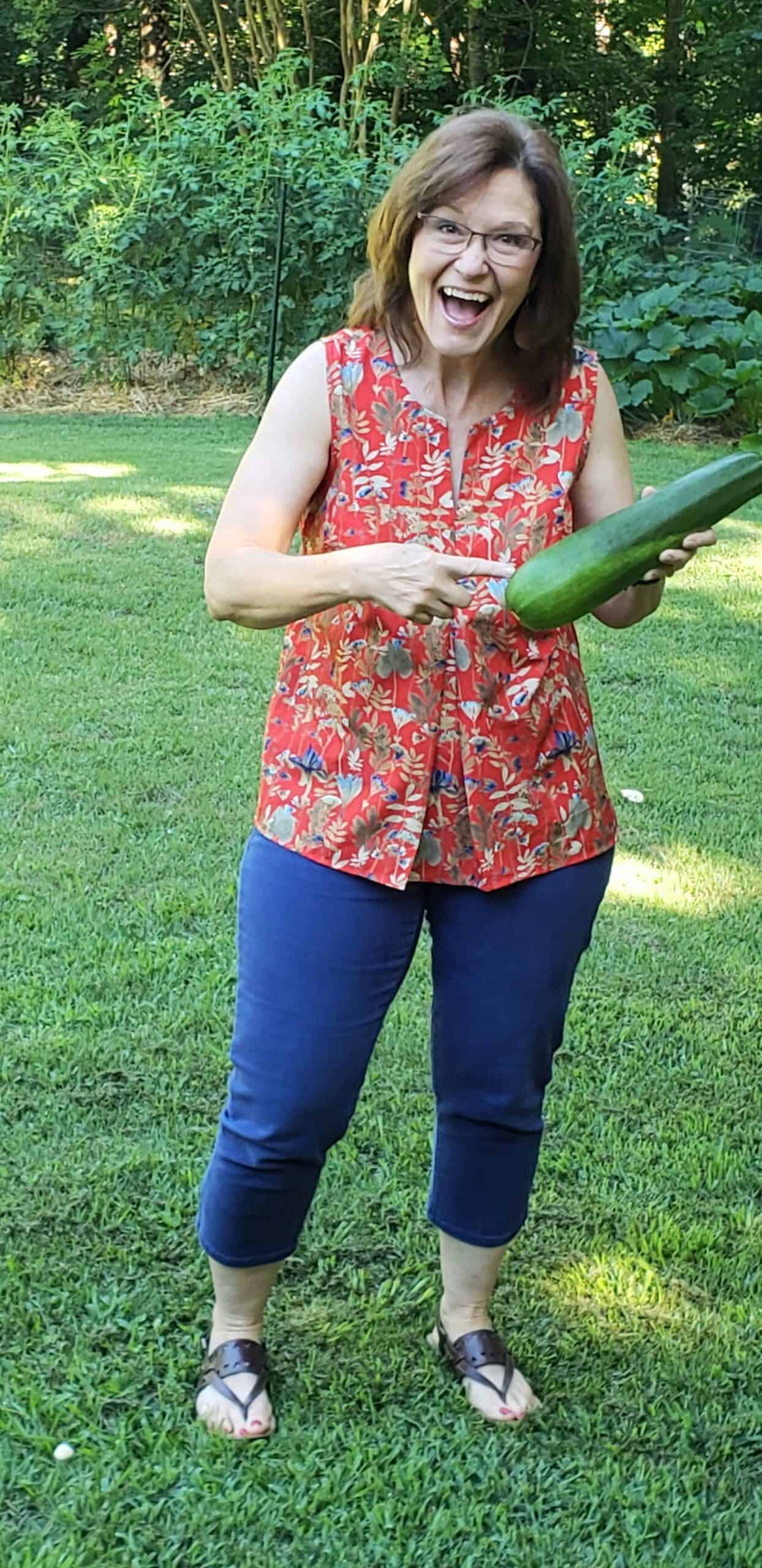 woman holding zucchini as big as a baseball bat
