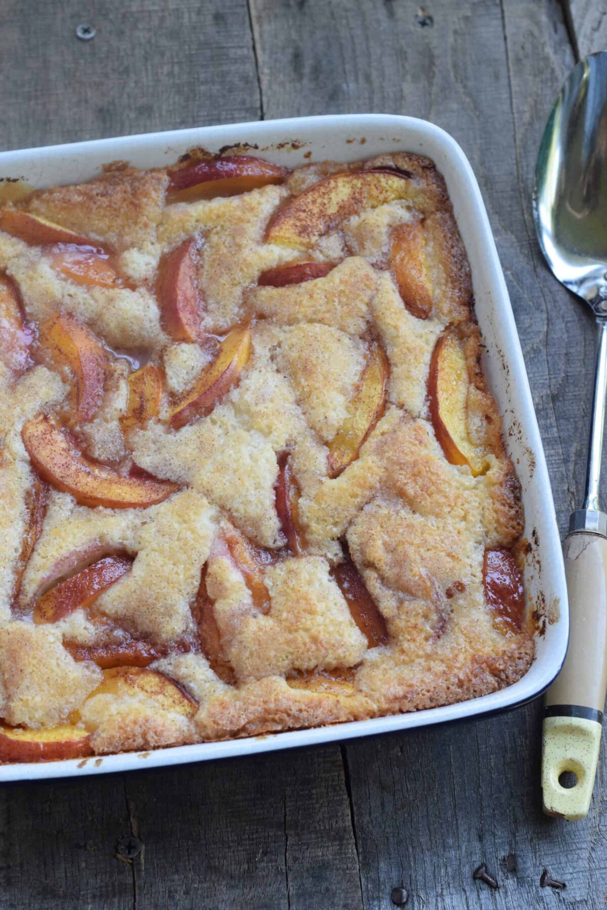 Easy Cinnamon Sugar Nectarine Cobbler Served in a square casserole dish with antique spoon.