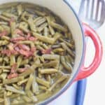 Rattlesnake green beans with bacon in red pot and antique spoon