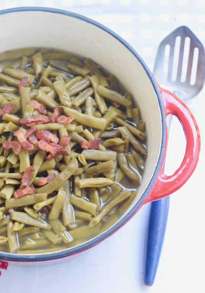 Rattlesnake green beans with bacon in red pot and antique spoon