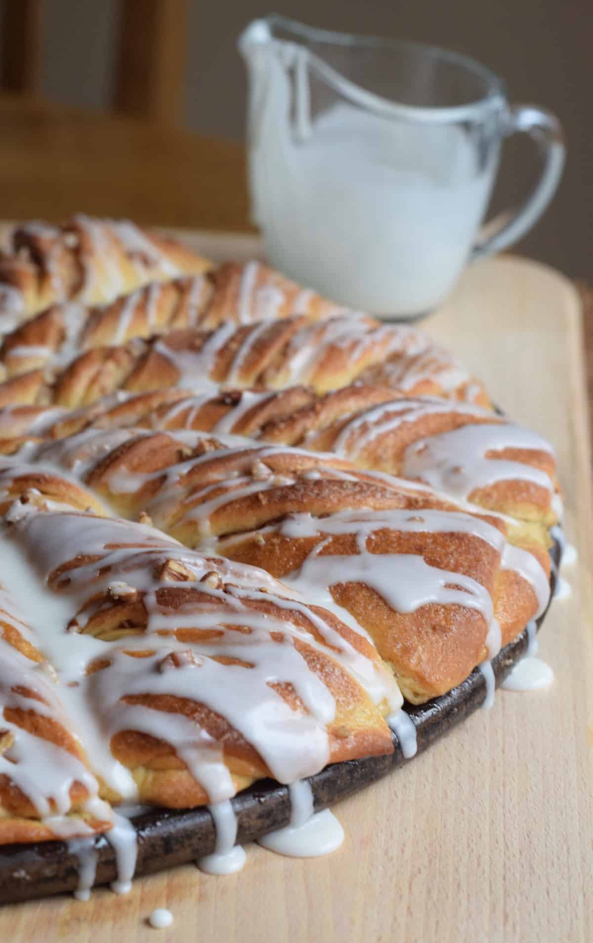 pecan topped twists of sweet rolls; drizzled icing over the sides and a small pitcher of icing