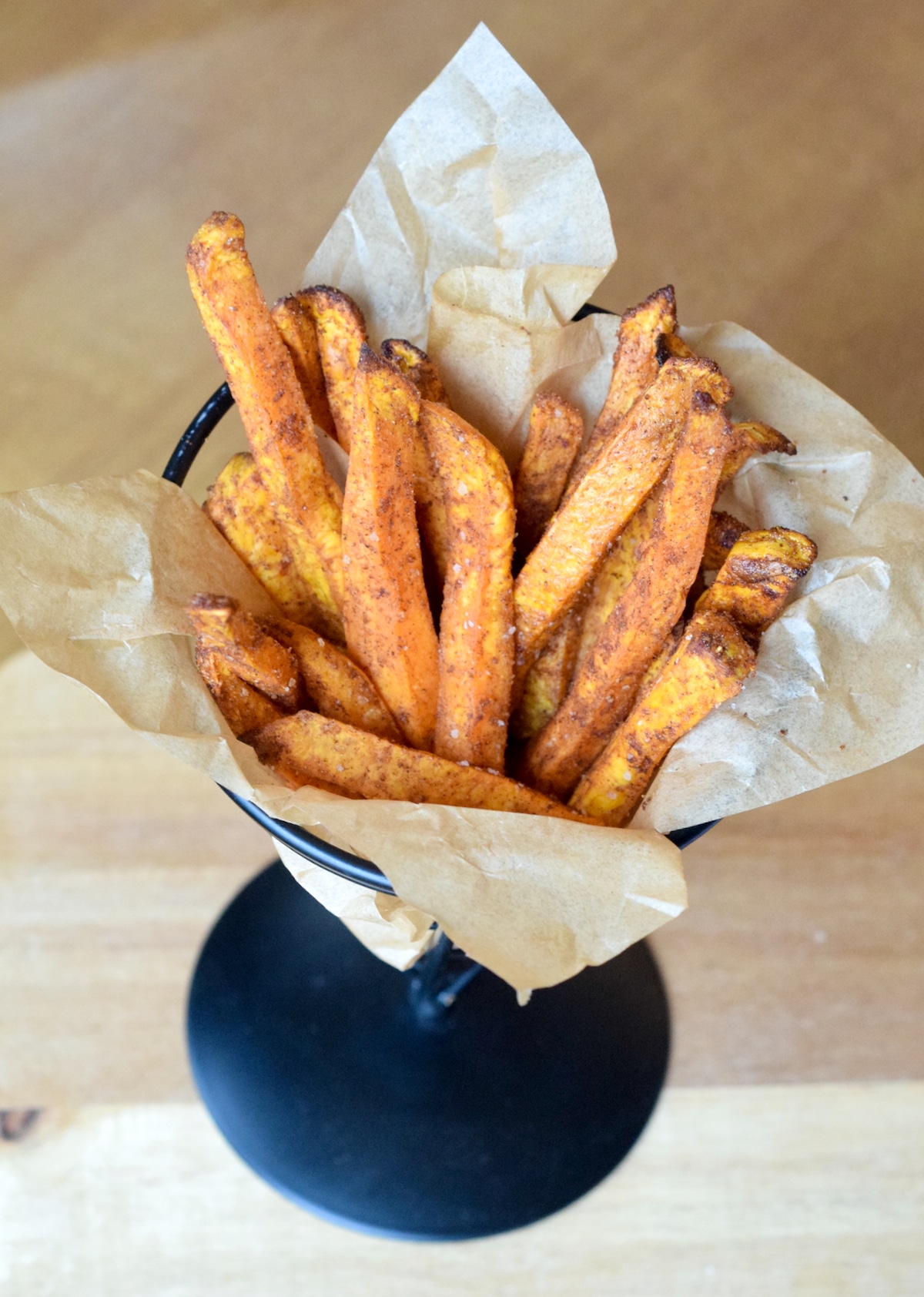 Air Fryer Spiced Sweet Potato Fries in parchment paper cooked in air fryer.