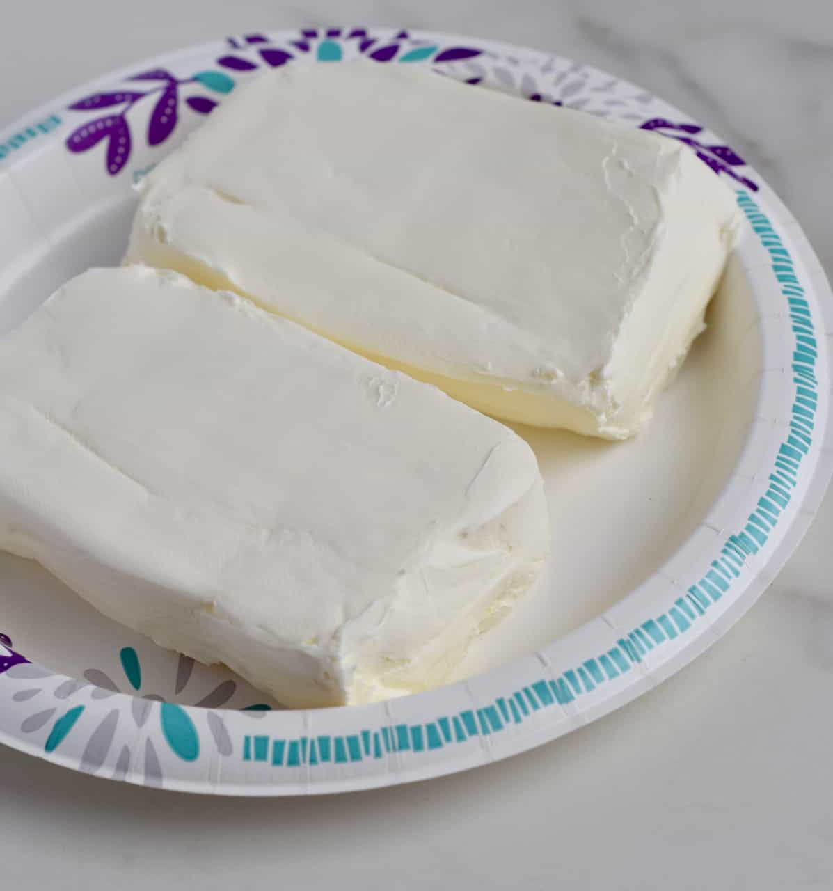  Cream cheese  blocks on a paper plate, unwrapped