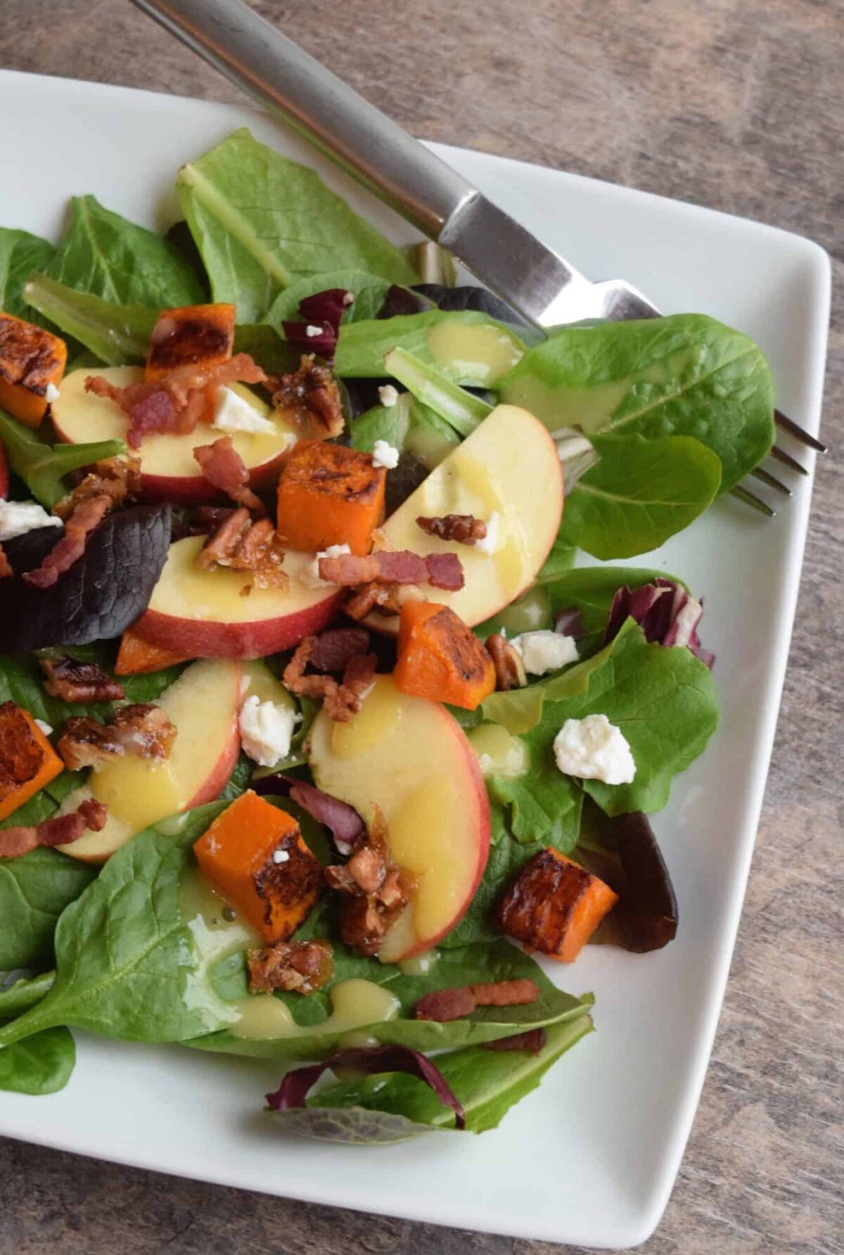 apple butternut salad on a white plate with fork