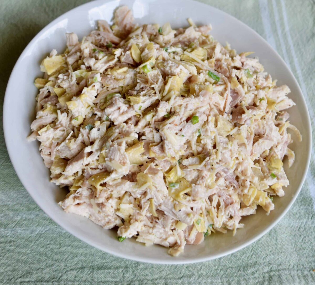 chicken salad with artichokes in a white rimmed plate