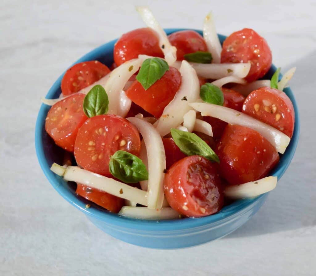 vidalia onions grape tomato basil salad in a blue bowl