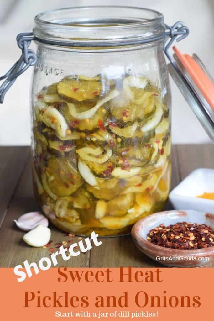 Old mason jar of pickles and onions with garlic and crushed red pepper on wooden surface