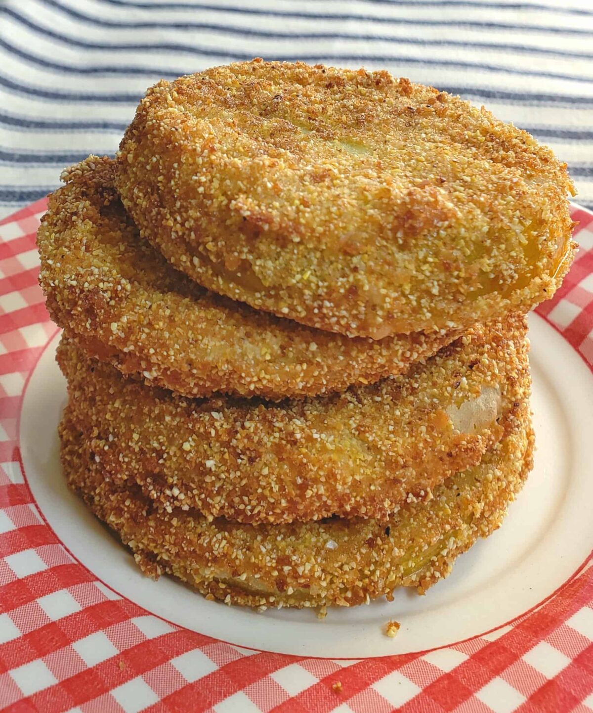 stack of fried green tomatoes on red checked plate