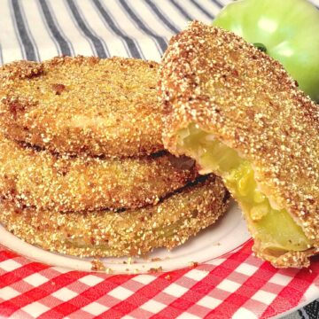 stack of 3 fried green tomatoes with a fourth one with bite out and propped up