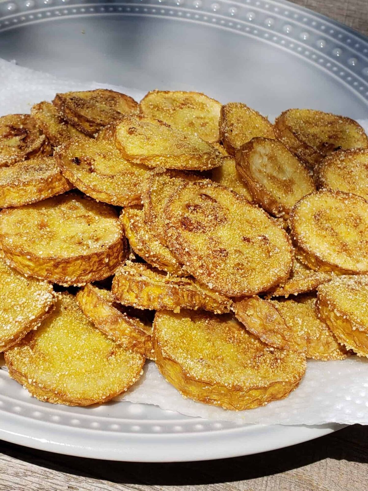 Fried Yellow Squash on a paper towel on a gray plate