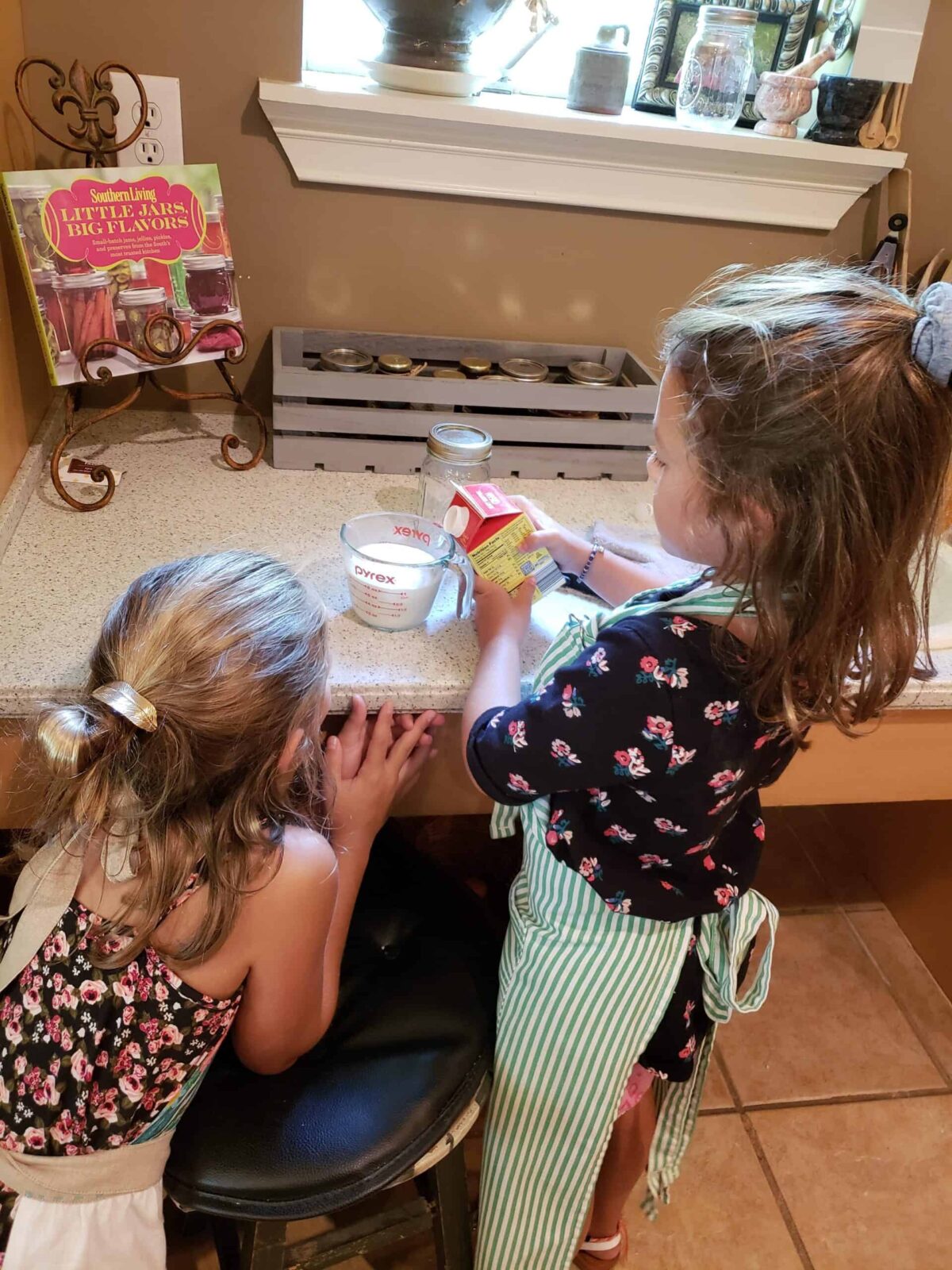 Little girls measuring whipping cream in a liquid measuring cup