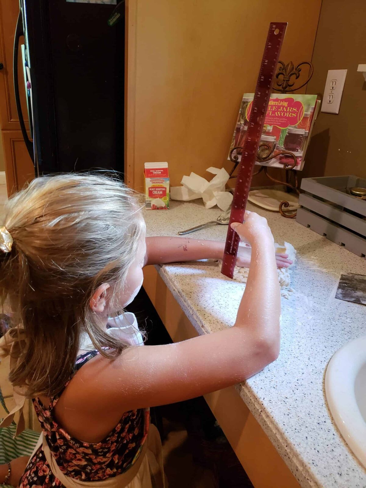 Girl measuring biscuit dough 3/4 inch thick