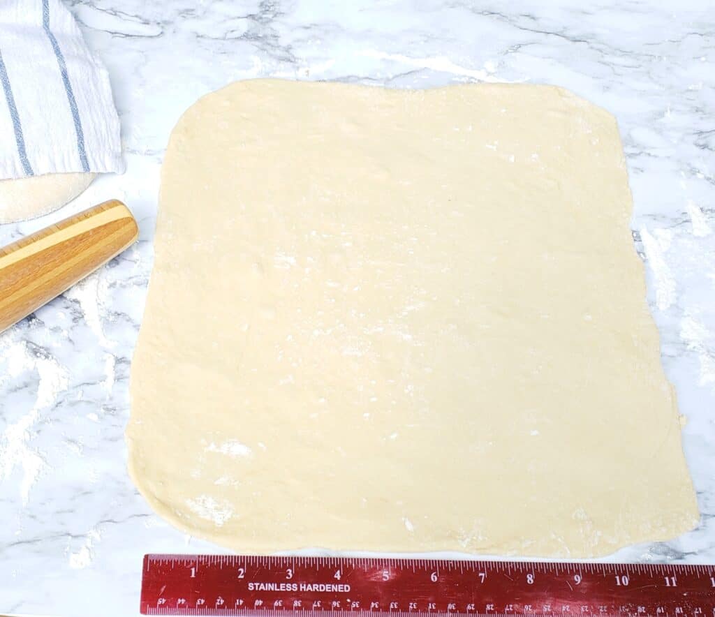 Cinnamon Roll dough rolled out with ruler and rolling pin