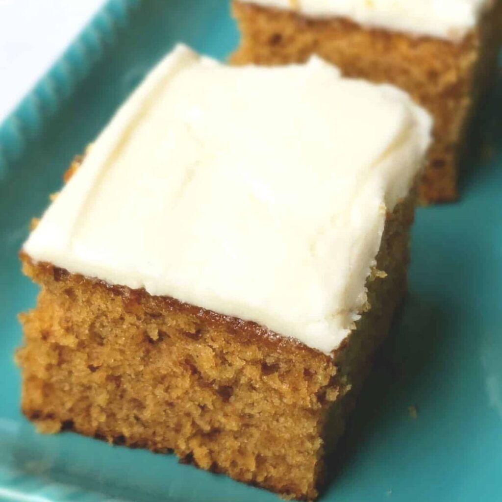 Squares of cake frosted on a turquoise platter