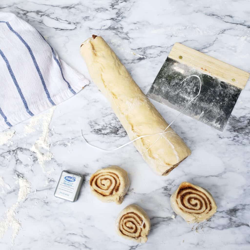 Cinnamon roll dough rolled in to a log ready for slicing