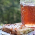 scuppernong jelly in jar with slice of crusty bread covered in jelly