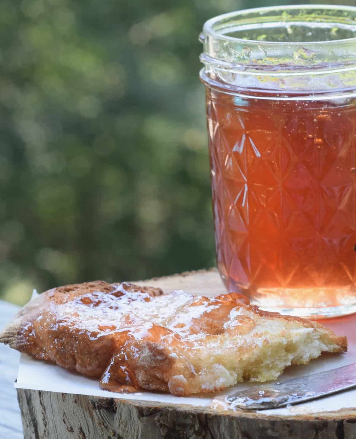 scuppernong jelly in jar with slice of crusty bread covered in jelly 