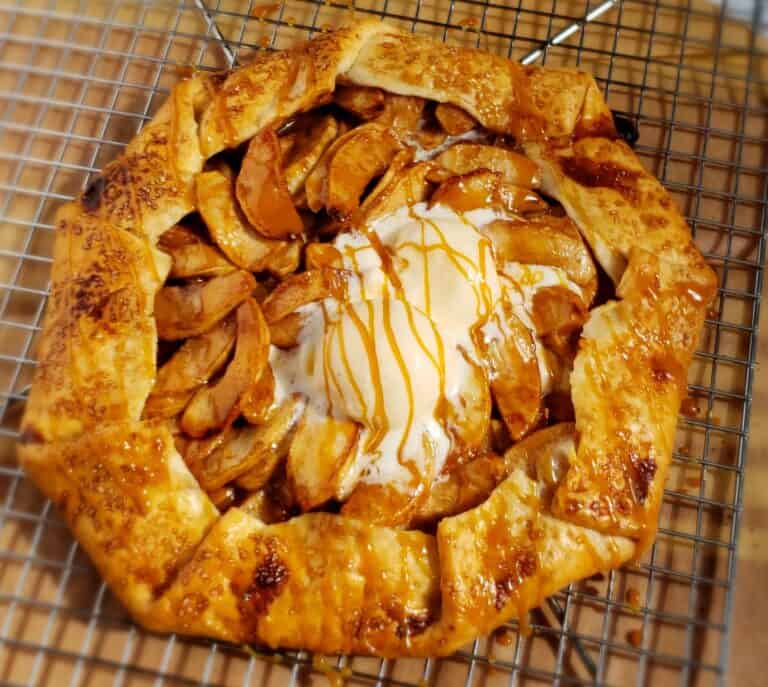 Apple pie galette with caramel drizzled and 2 scoops vanilla ice cream