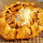 Apple galette with caramel drizzled on the melting ice cream. The shortcut apple pie is placed on a wire rack