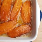 sweet potatoes cut in half lengthwise candied in white casserole dish