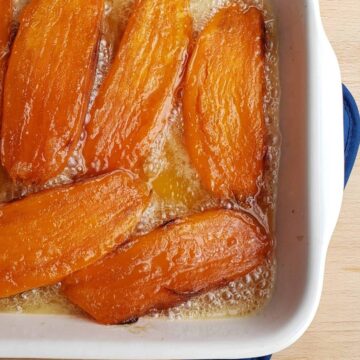 sweet potatoes cut in half lengthwise candied in white casserole dish