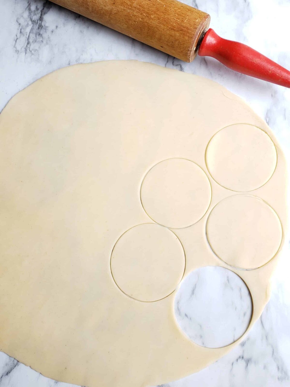 Cut pie dough into rounds with a rolling pin