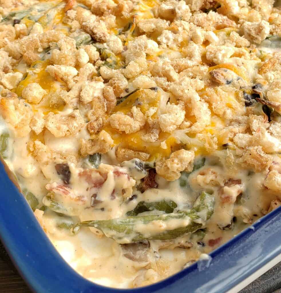 Keto and Gluten Free Green Bean Casserole with a scoop taken out of the blue casserole dish