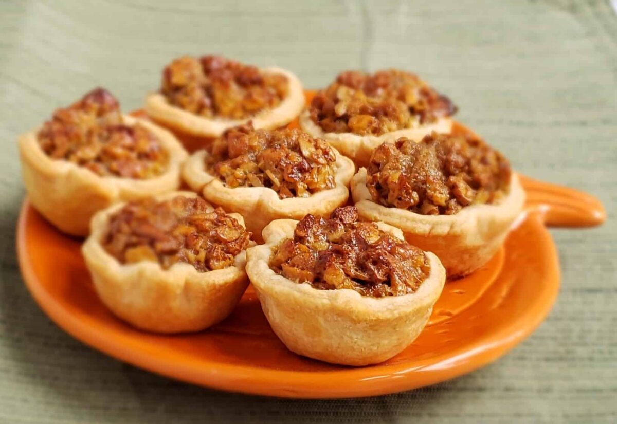 Seven Maple Pecan Tassies on an orange pumpkin shaped plate