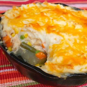 Shepherds Pie made with leftover Thanksgiving turkey vegetables and gravy. Made in a cast iron skillet with multi colored cloth.