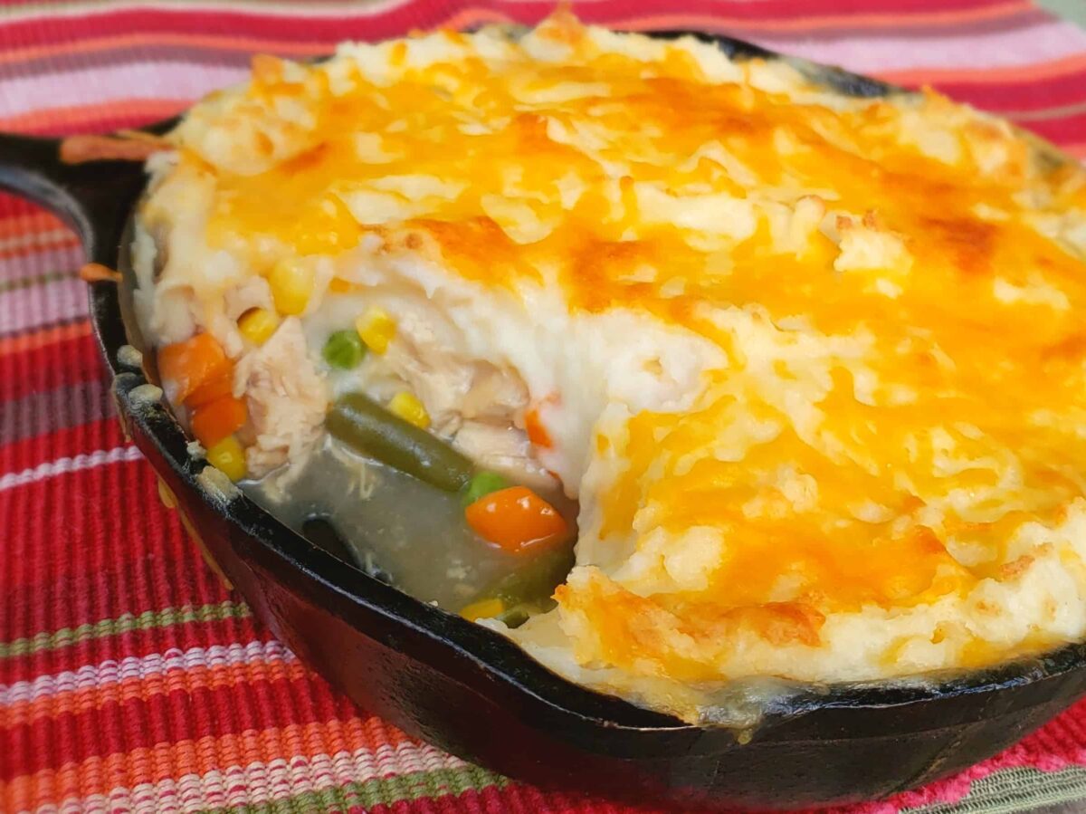 Shepherds Pie made with leftover Thanksgiving turkey vegetables and gravy. Made in a cast iron skillet with multi colored cloth.