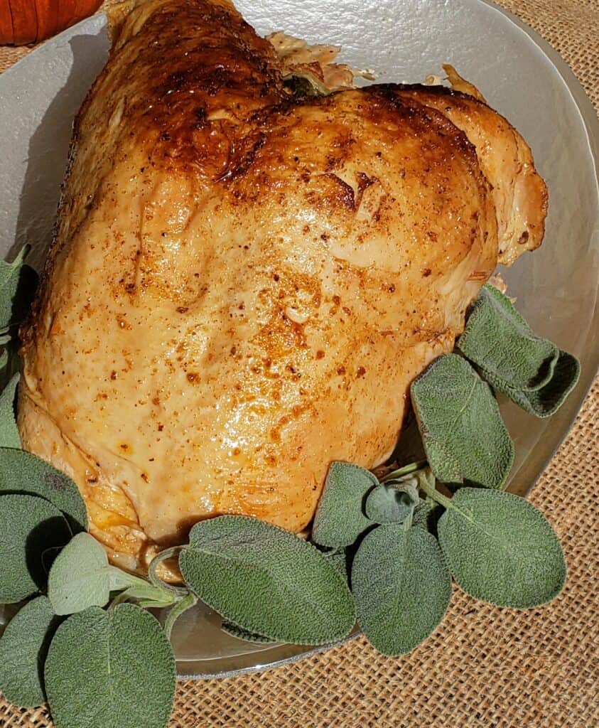 Turkey Breast on a glass platter with sage garnish