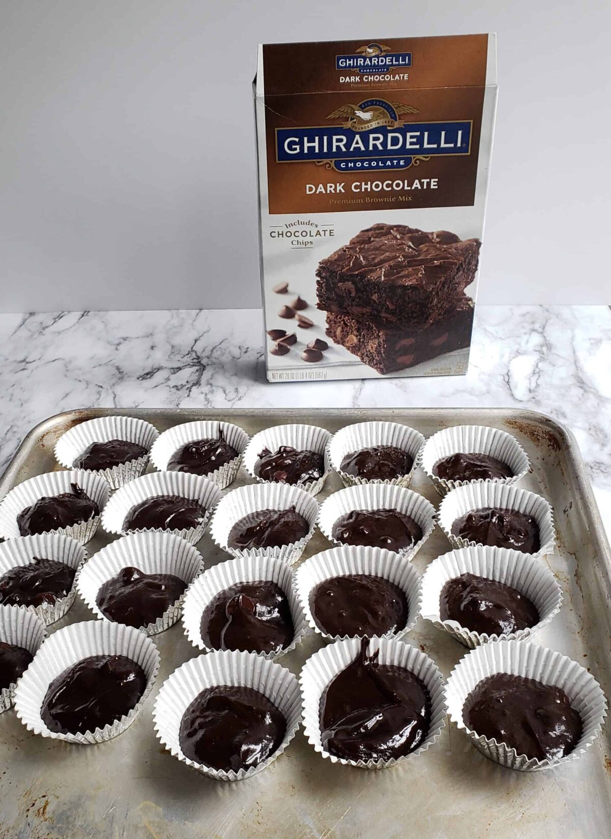 Ghiradelli brownie mix box and batter in mini muffin paper liners.