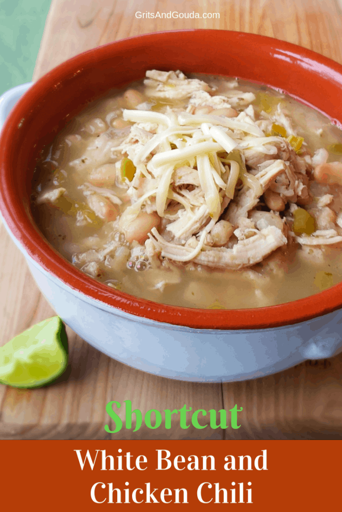 white bean chicken chili in tera cotta bowl on wooden cutting board