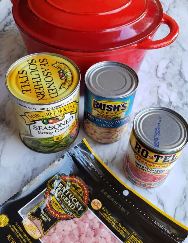 Shortcut Turnip Greens Soup is made with just 4 ingredients and 3 of them are cans of veggies but it tastes like fresh greens were cooked low and slow all day. Cans of turnip greens, great northern bean, Rotel tomatoes, diced ham with a red cast iron dutch oven.