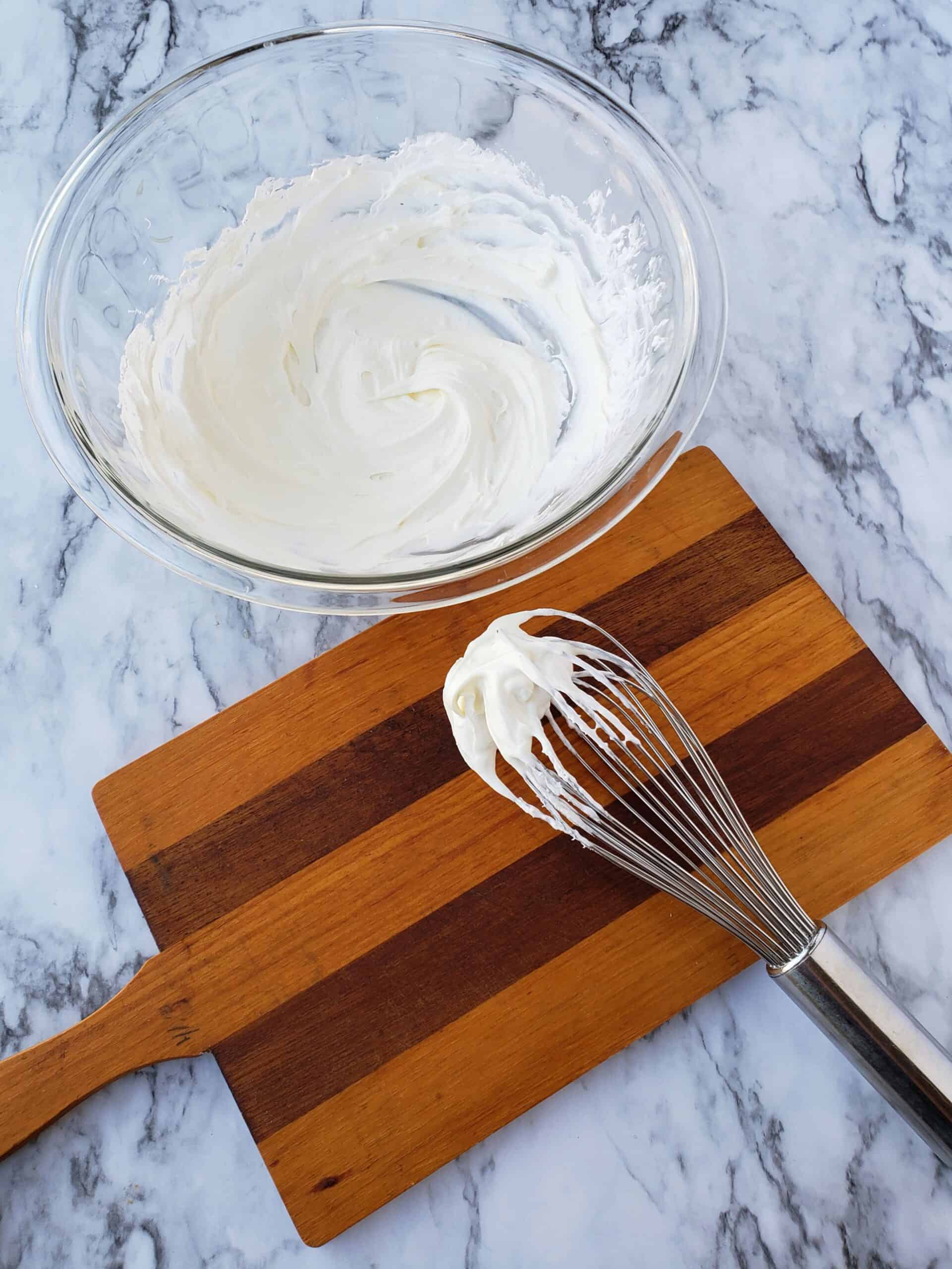 Neufchatel and sugar free Coo Whip stirred together with a wire whisk on wooden cutting board