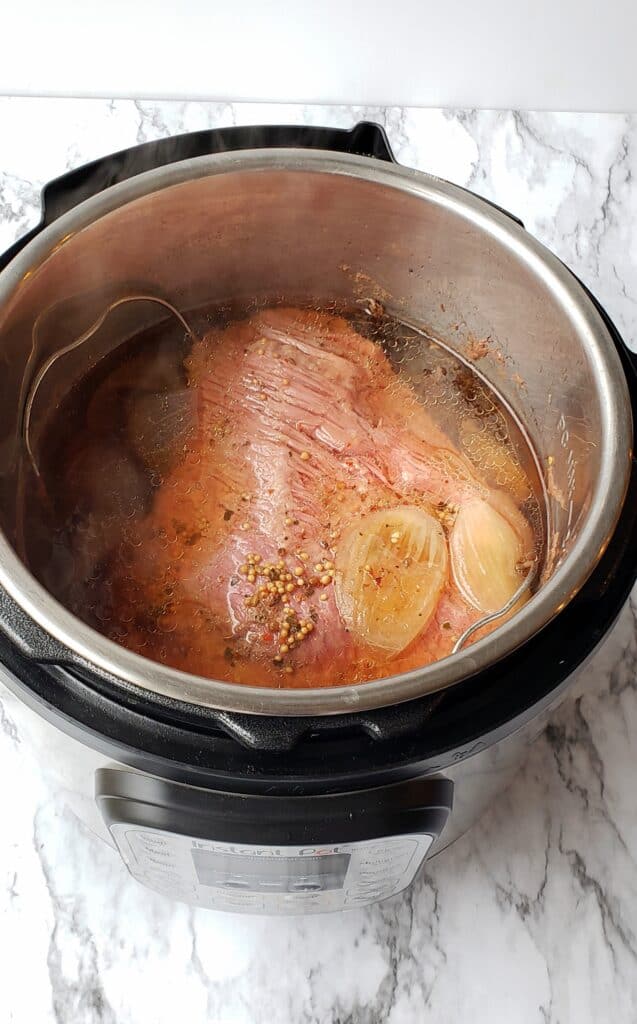 Seal the lid on the Instant Pot and cook on Manual or Pressure Cook for 1 hour and 40 minutes for a 4 pound corned beef. One hour and 30 minutes for a 3.5 pound brisket.