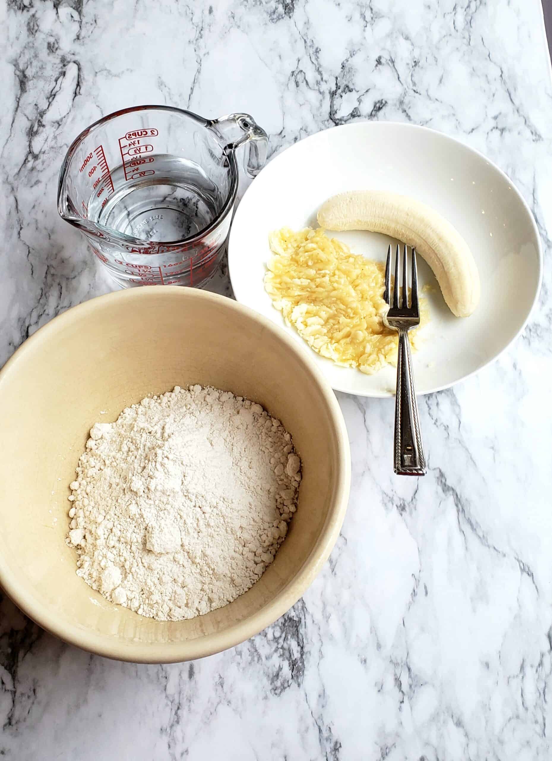  Krusteaz pancake mix in a bowl and mashed bananas with a fork