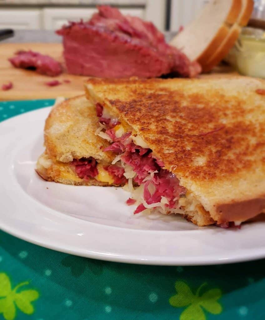 Building a Reuben Sandwich with Instant Pot Corned Beef is easy by layering it with shredded Swiss cheese and sauerkraut. Slather the inside of the bread with Russian or Thousand Island Dressing. I like to cook mine on a griddle or skillet like a grilled cheese to melt the cheese.
