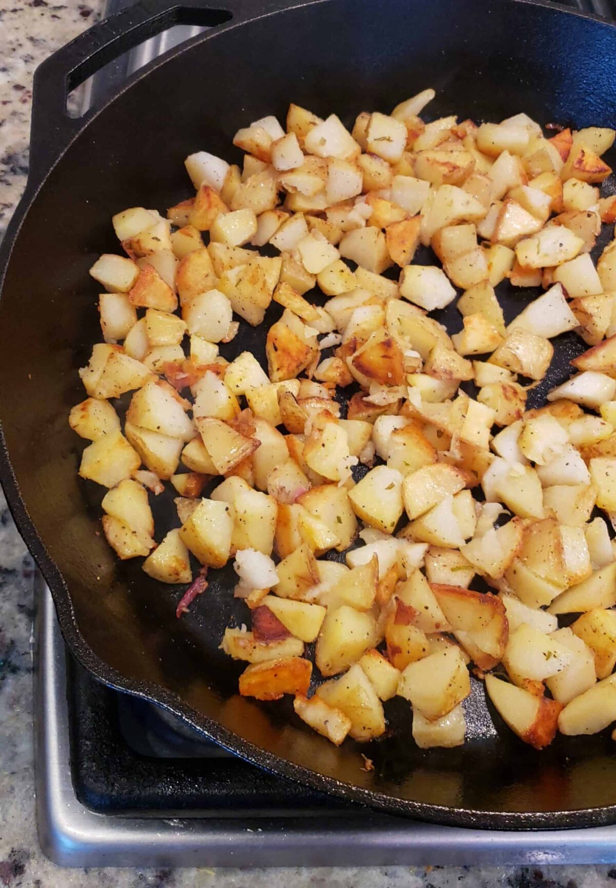 fried chopped potatoes with red skins in a cast iron skillet