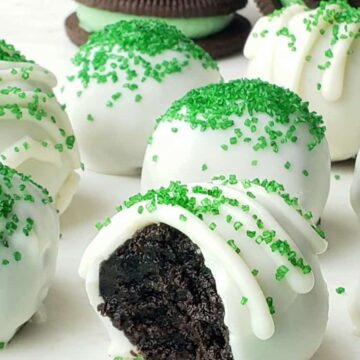 Oreo balls Coated in white chocolate and topped with green sprinkles,