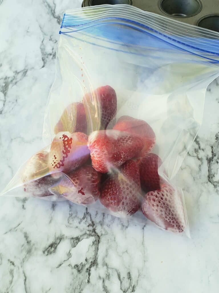 Pack frozen fresh strawberries in a zip top plastic bag after freezing them in muffin tins. This way it's easy to pull just a few out at a time to make Frozen Strawberry and Sweet Tea Lemonade any time.