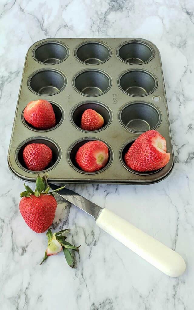 To freeze fresh strawberries remove the green caps first. Then freeze in mini muffin pans or a cookie sheet depending on how many you want to freeze.