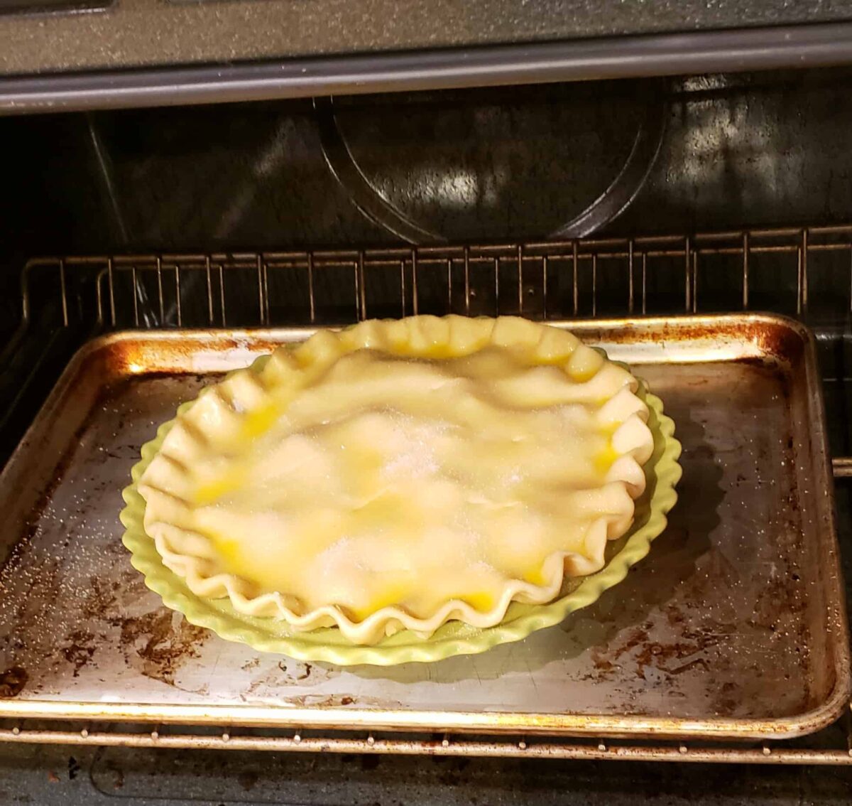 Pie on a baking sheet in oven before baking