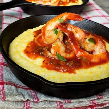 shrimp and grits in two cast iron skillets