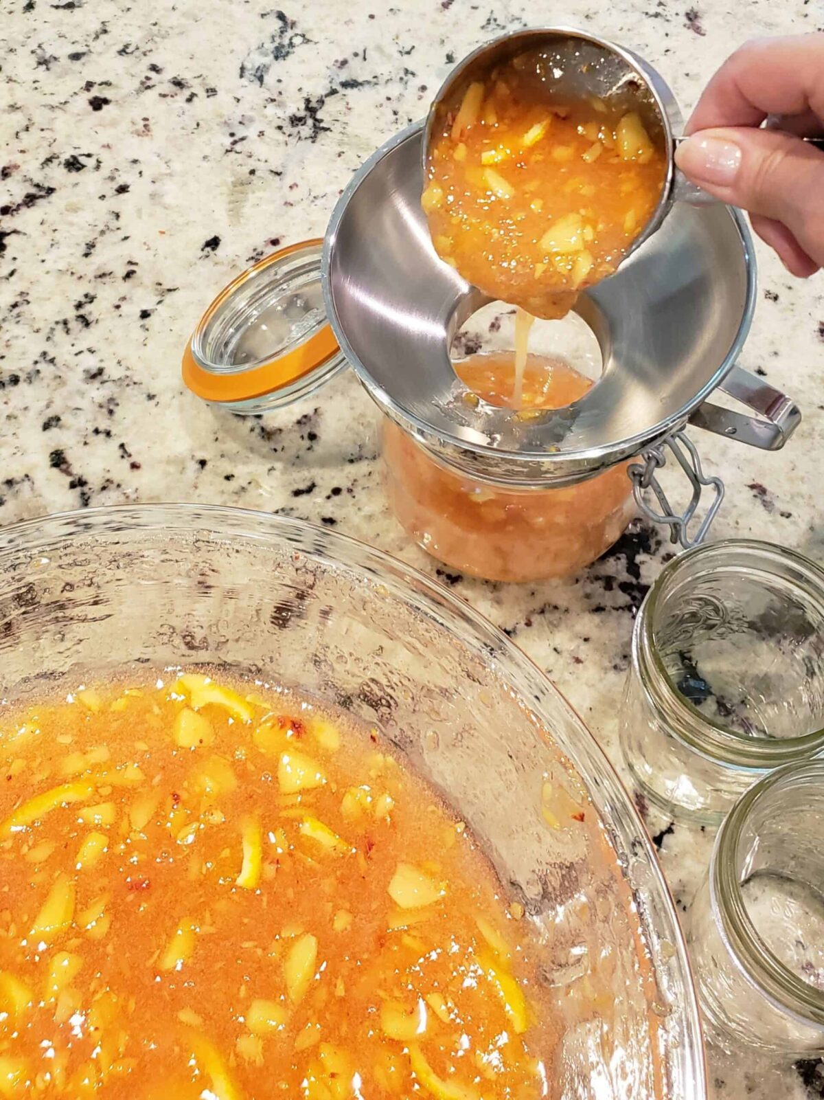 Spoon peach marmalade mixture into glass jars or plastic freezer containers using a canning funnel to prevent spills.