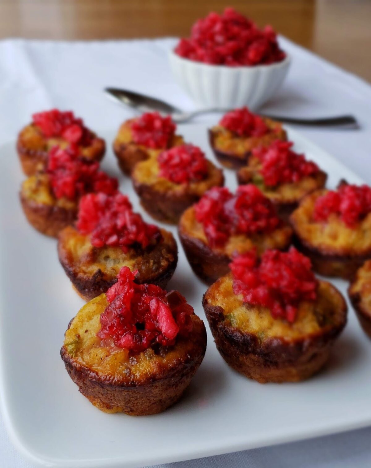 Cornbread dressing baked in mini muffin cups topped with Cranberry salsa