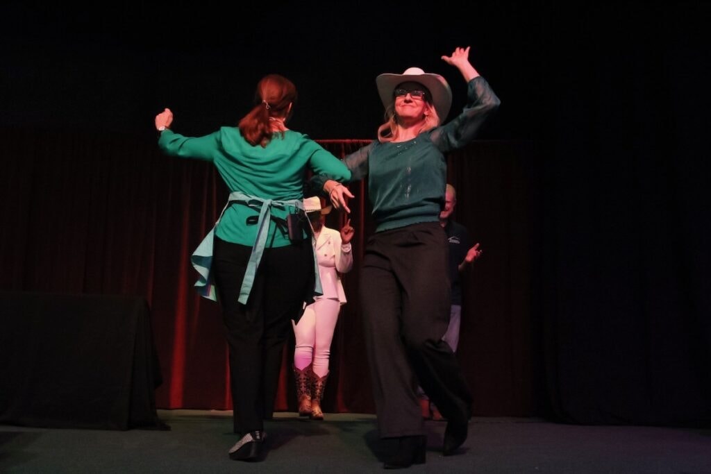 Two women square dancing on stage,