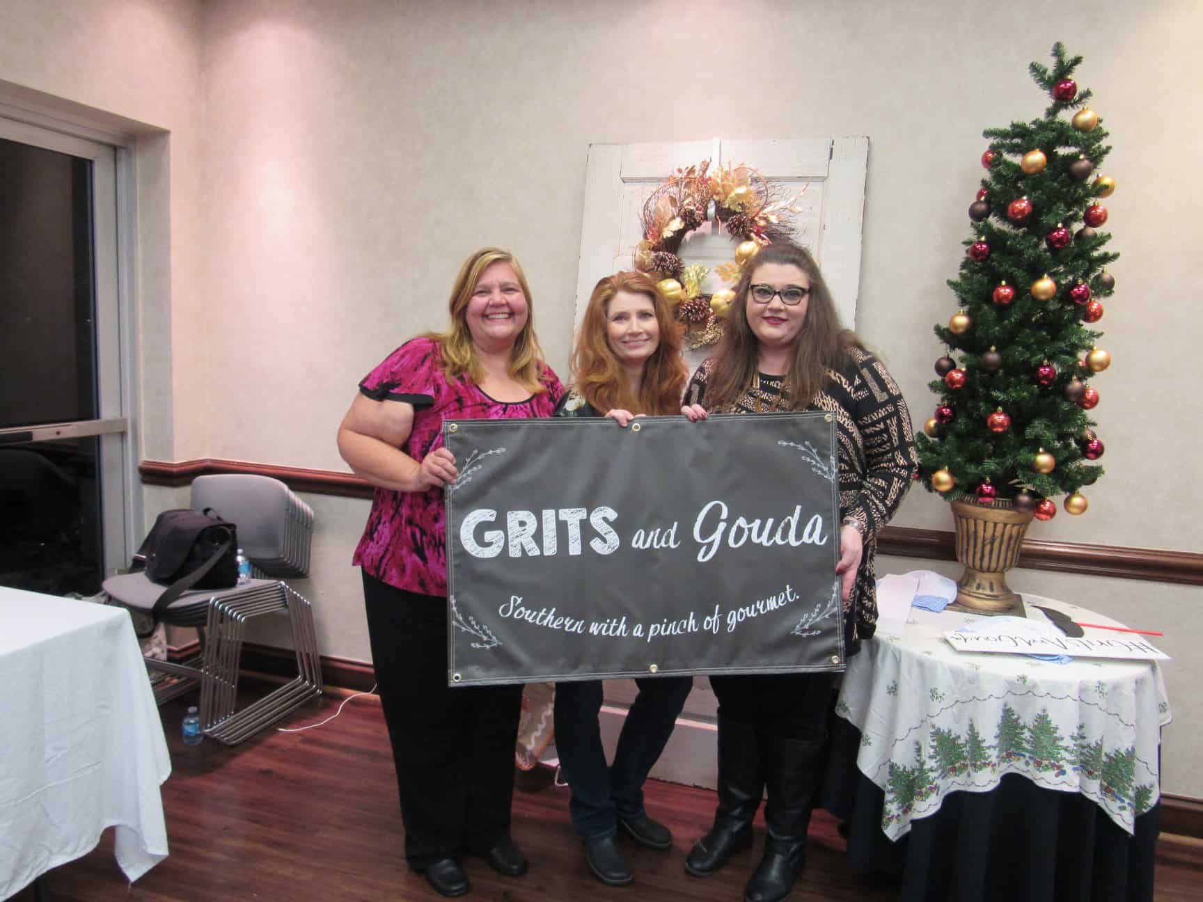 Guests holding up Grits and Gouda banner by selfie station