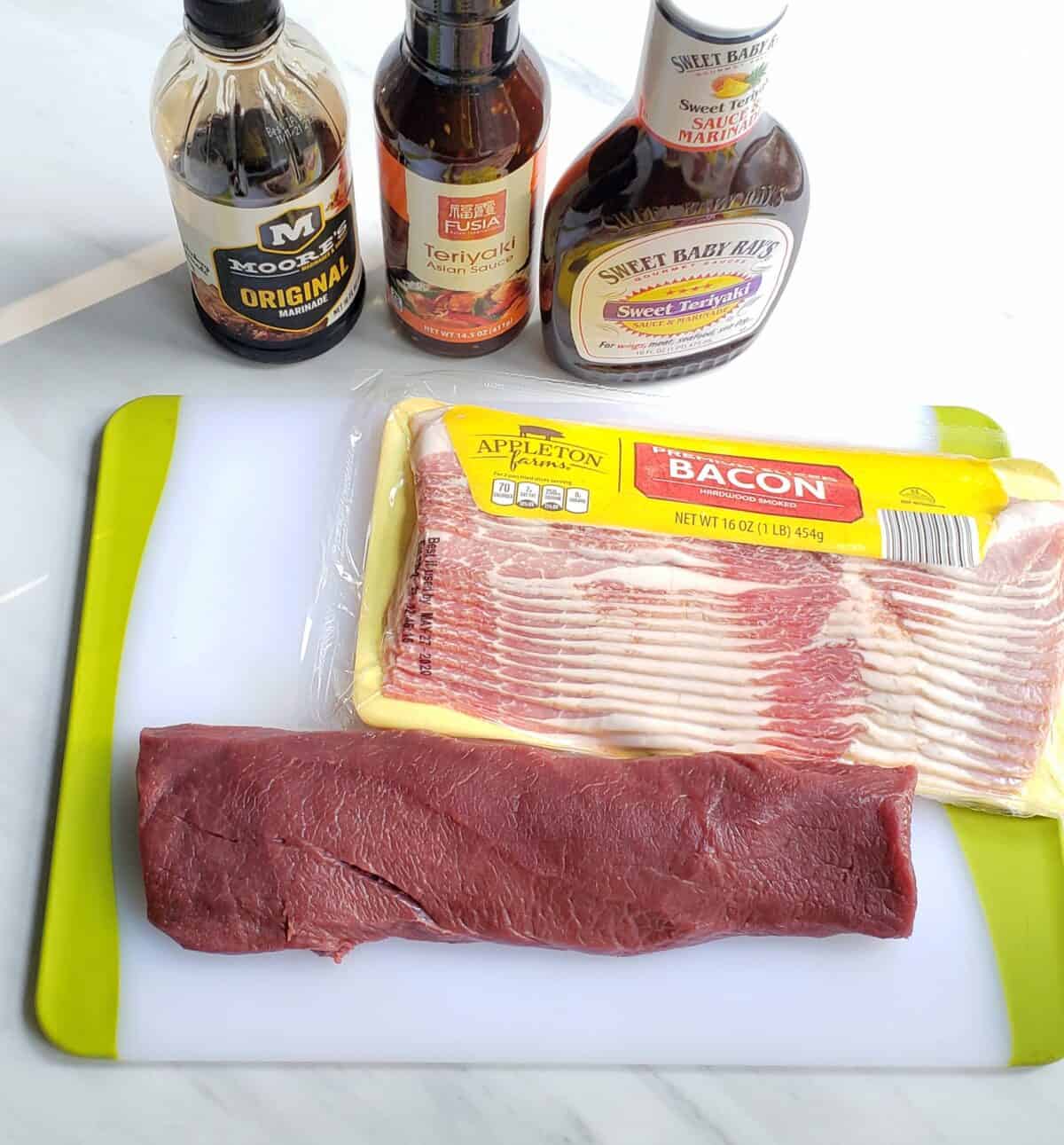 ingredients: bacon, venison roast, teriyaki sauce on a cutting board