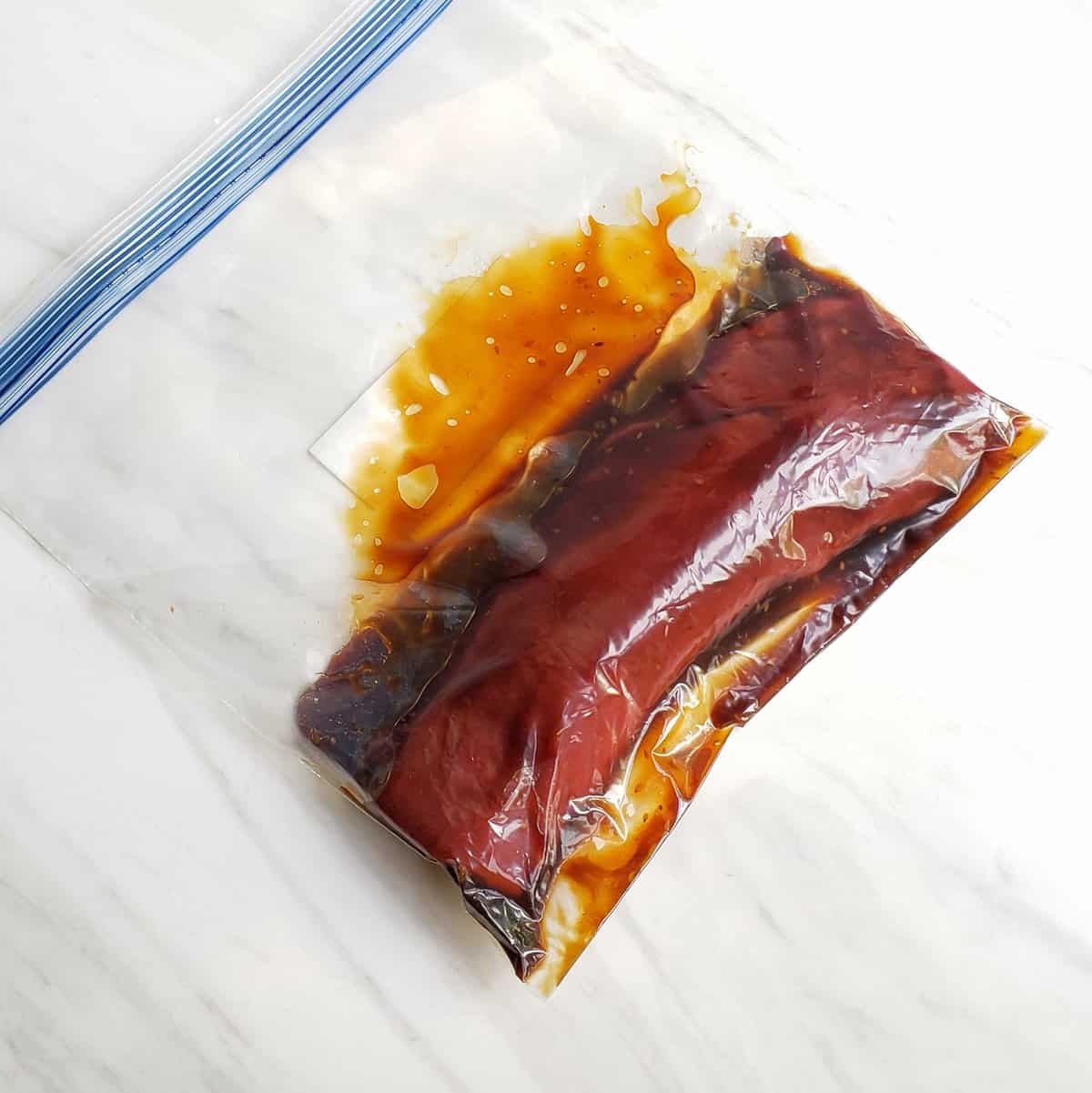 venison roast marinating in teriyaki sauce in zip top bag